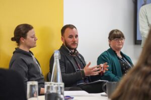 Three people sat in a line up for a panel event